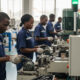 African factory workers operating machinery in a local manufacturing plant, symbolizing industrial growth and economic empowerment across the continent