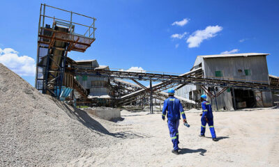Zimbabwe lithium mine with heavy machinery, highlighting the country's plan to ban raw lithium concentrate exports by 2027 for local processing and EV battery production.