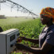 Farm worker operating a center pivot irrigation system on a mechanized farm in Africa, symbolizing the role of smart agriculture in enhancing food security and sustainability.