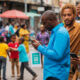 Diverse group of people using smartphones in urban African settings, illustrating growing internet access and affordability
