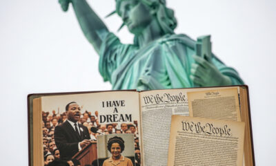 Statue of liberty with faded American history book showing images of Black inventors, civil rights leaders, and founding documents, symbolizing the importance of preserving truthful and inclusive U.S. history education