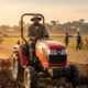 African farmer working in a sunlit field with modern farming tools, symbolizing the untapped potential of Africa’s agribusiness and the future of sustainable agriculture on the continent.