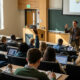 University lecture hall with professor teaching students, representing U.S. higher education academic environment.