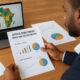 Investor analyzing African market growth and investment opportunities across sectors like fintech, agriculture, and infrastructure on a digital dashboard with maps, charts, and demographic trends.