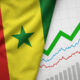 Symbolic image representing economic sovereignty (Senegalese flag intertwined with economic charts/growth arrows)