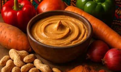 Traditional West African groundnut stew with peanut butter base, served in a clay bowl with vegetables, highlighting the cultural and culinary importance of peanuts in African cuisine.
