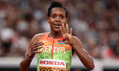 Faith Kipyegon crosses finish line to win 4th 1500m world title at Tokyo World Athletics Championships, wearing Kenyan kit and raising arms in victory.