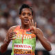 Faith Kipyegon crosses finish line to win 4th 1500m world title at Tokyo World Athletics Championships, wearing Kenyan kit and raising arms in victory.