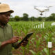 African farmers using data-driven technology, including sensors, drones, and mobile apps, to optimize irrigation, monitor crops, and improve yields across diverse farming landscapes.