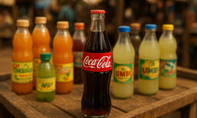 Coca-Cola bottle on an African market stall surrounded by local beverages, symbolizing the shift from global uniformity to local identity in African consumer culture.