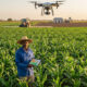 African farmer using drones and mechanization for precision agriculture to monitor crop health and improve sustainable farming practices.