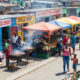 Vibrant street market in a South African township with spaza shops, food vendors, and entrepreneurs at work—showcasing the structured, productive reality of the so-called "informal" economy.