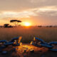 A broken chain next to a rising sun over the African savanna, symbolizing breaking silence and a new dawn