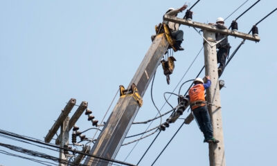 Rural African community benefiting from electrification with powered agro-processing, small businesses, cold storage, and irrigation systems driving economic growth and transformation.