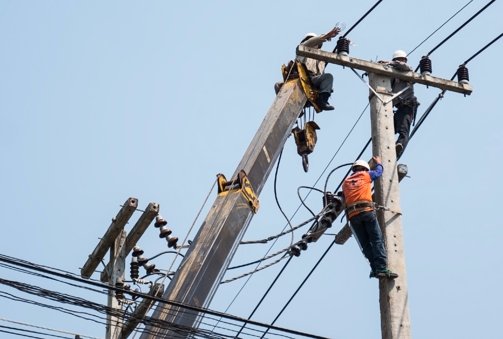 Rural African community benefiting from electrification with powered agro-processing, small businesses, cold storage, and irrigation systems driving economic growth and transformation.