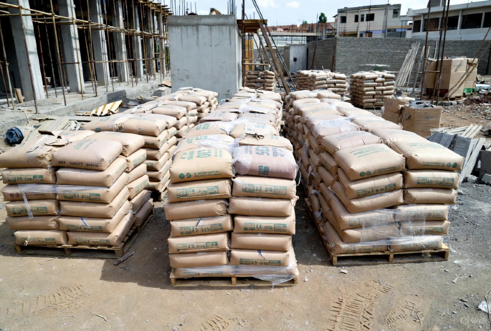 Cement bags stacked at construction site in Uganda showing industrial manufacturing challenges