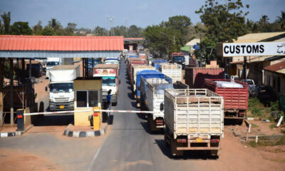 West African customs checkpoint with trucks waiting in line at a border crossing