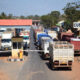 West African customs checkpoint with trucks waiting in line at a border crossing
