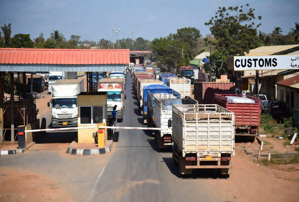 West African customs checkpoint with trucks waiting in line at a border crossing