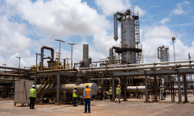 African oil refinery with workers symbolizing resource nationalism debate