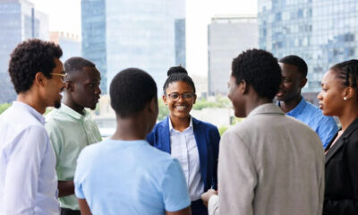 A diverse group of young African professionals in dialogue, representing reflection amid progress.