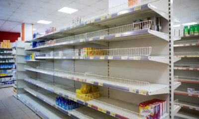 Empty retail shelves in an African store, symbolizing the gap between consumer demand and local manufacturing capacity.