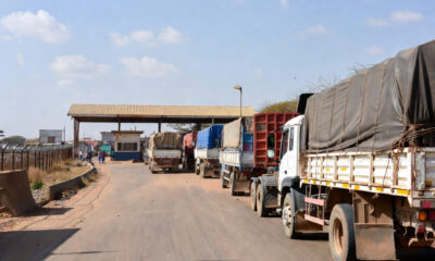 Freight trucks waiting at a West African border post along the Abidjan-Lagos Corridor, highlighting trade inefficiencies despite major road infrastructure investment.