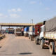 Freight trucks waiting at a West African border post along the Abidjan-Lagos Corridor, highlighting trade inefficiencies despite major road infrastructure investment.