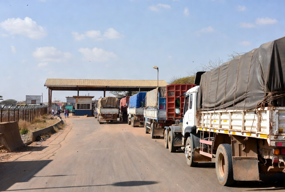 Freight trucks waiting at a West African border post along the Abidjan-Lagos Corridor, highlighting trade inefficiencies despite major road infrastructure investment.