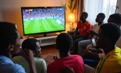 African football fans watching World Cup match on television from home due to visa restrictions