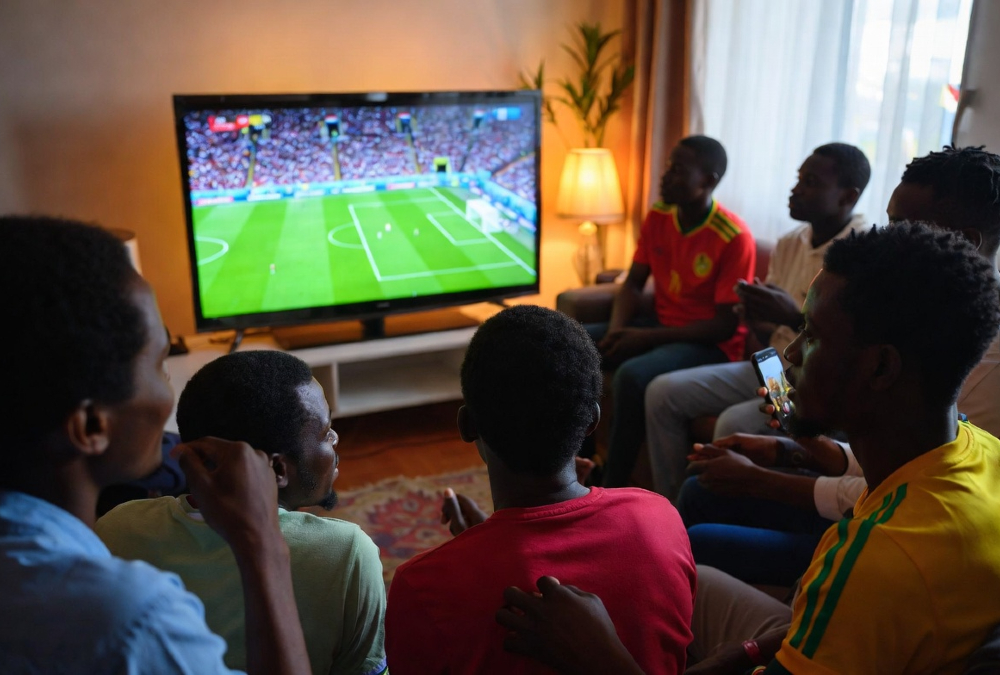 African football fans watching World Cup match on television from home due to visa restrictions