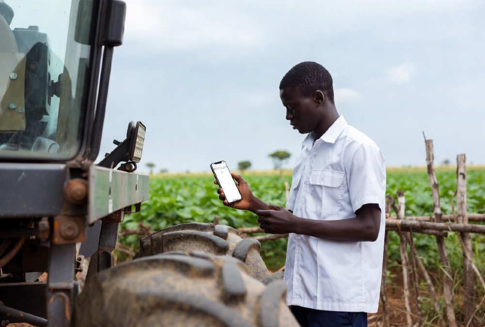 Smallholder farmer using mobile AI tool for localized agricultural guidance, contrasting high-tech farm machinery with real-world decision-making needs in sub-Saharan Africa.
