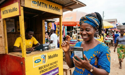 A person in Africa using a mobile phone to receive a remittance payment from a family member overseas.