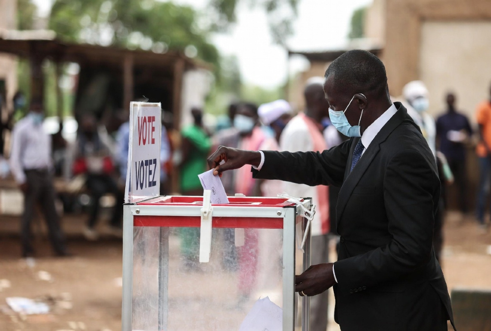 A voter casting a ballot in Africa, representing the 2026 elections that will filter disciplined multinational capital from undisciplined investment.