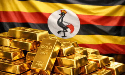 Gold bars stacked with Uganda flag in background illustrating surge in Uganda’s gold exports surpassing coffee in 2025