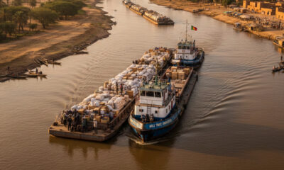 Cargo vessels navigating the Senegal River to connect inland Mali with Atlantic trade routes under Organisation pour la Mise en Valeur du Fleuve Sénégal regional infrastructure cooperation.