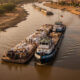 Cargo vessels navigating the Senegal River to connect inland Mali with Atlantic trade routes under Organisation pour la Mise en Valeur du Fleuve Sénégal regional infrastructure cooperation.