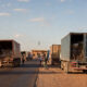 African border crossing with customs officials inspecting cargo trucks, highlighting trade facilitation, regional integration, and economic growth challenges in Africa