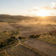 Aerial view of vast uncultivated arable farmland in Africa at golden hour, representing agricultural investment opportunity