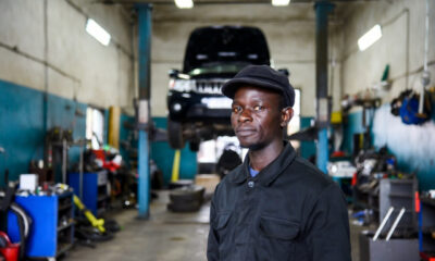 African entrepreneur at automotive service center, illustrating lowered entry barriers under the agency retail model