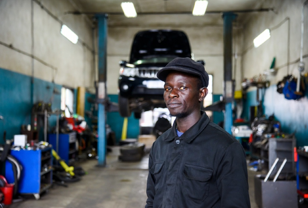 African entrepreneur at automotive service center, illustrating lowered entry barriers under the agency retail model
