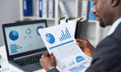 A professional African investor reviewing financial documents and data charts representing African market investment opportunities, illustrating the gap between available capital and investment-ready deals in Africa.