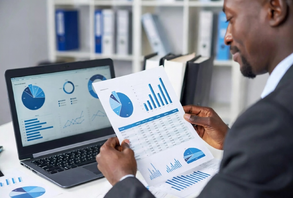 A professional African investor reviewing financial documents and data charts representing African market investment opportunities, illustrating the gap between available capital and investment-ready deals in Africa.