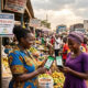 African woman trader using mobile payment for cross-border commerce via PAPSS-PesaLink integration
