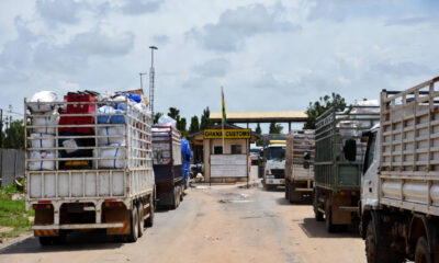 Ghana-Togo border post with Trucks with goods in transit, representing the tension between formal trade frameworks and informal reality in West Africa