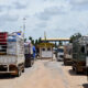 Ghana-Togo border post with Trucks with goods in transit, representing the tension between formal trade frameworks and informal reality in West Africa