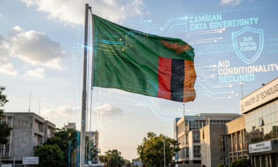 Please generate a realistic image of dimensions 1536 by 1024 from the following theme: Zambian flag with digital data streams symbolizing data sovereignty and refusal of US aid conditions.