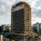 Crumbling corporate skyscraper symbolizing the decline of 'too big to fail' legacy institutions in a modern innovation-driven economy