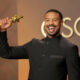 Michael B. Jordan holding his 2026 Best Actor Oscar for Sinners at the Academy Awards, making history as the sixth Black actor to win the award.
