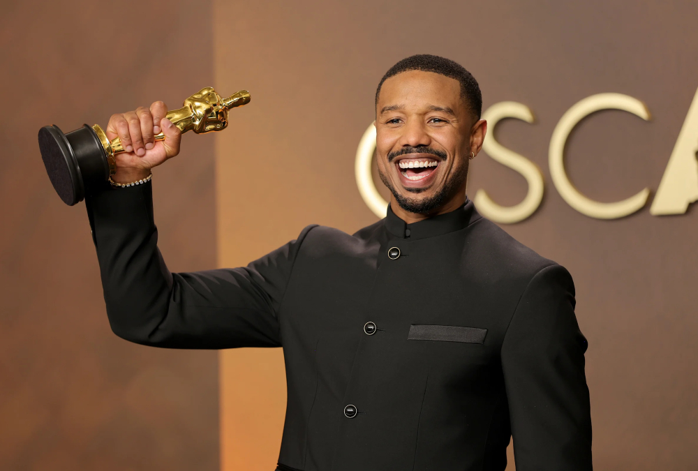 Michael B. Jordan holding his 2026 Best Actor Oscar for Sinners at the Academy Awards, making history as the sixth Black actor to win the award.